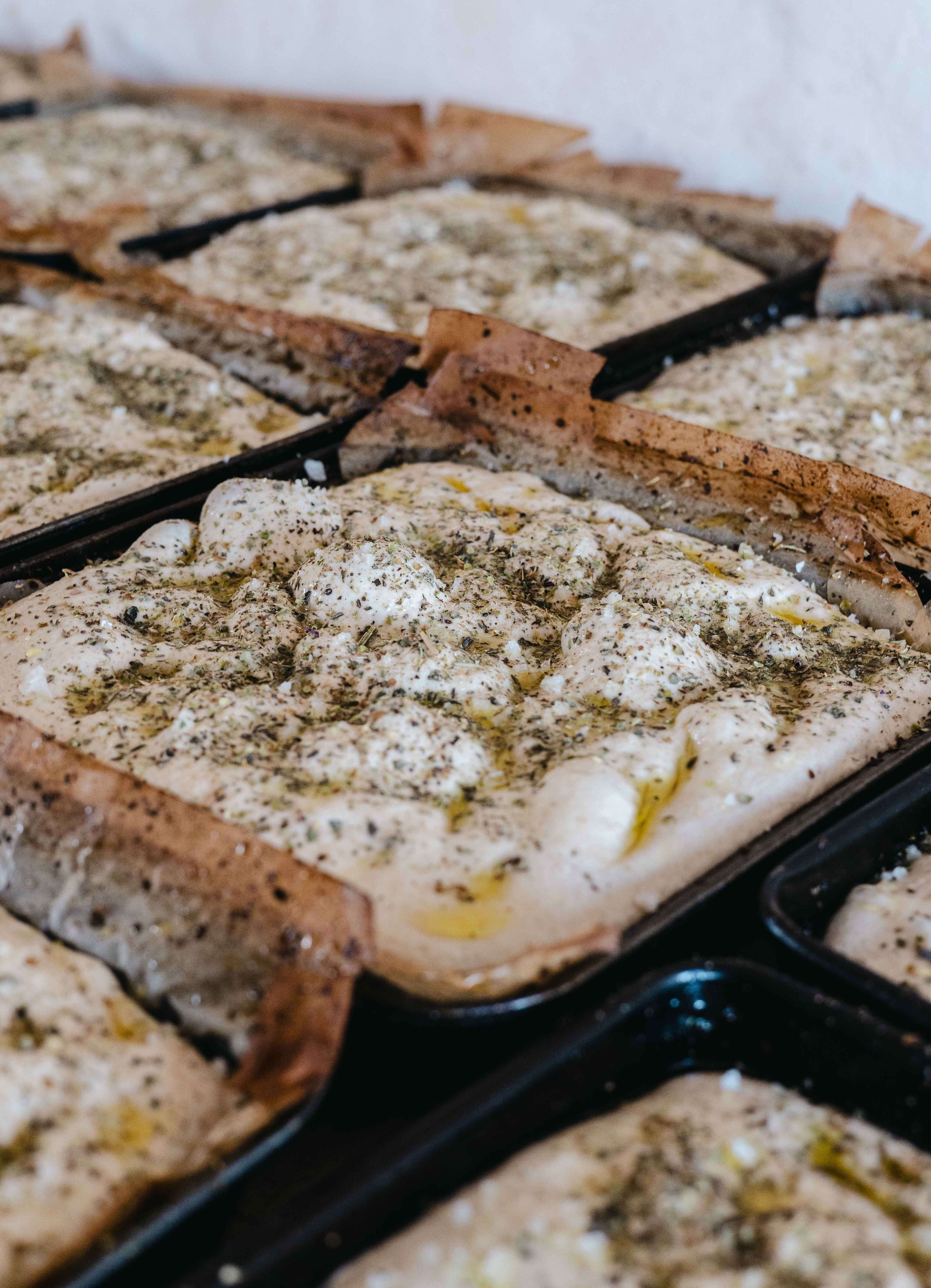 Focaccia duona kvepianti žolelėmis paruošta pašauti į krosnį. 